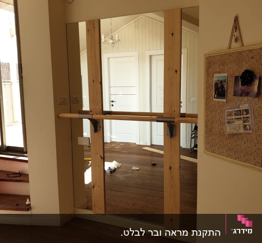 מראה גדולה עם מסגרת עץ על קיר